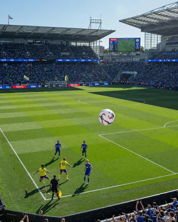 Football pitch in a daytime league stadium with the centre spot and goalposts visible